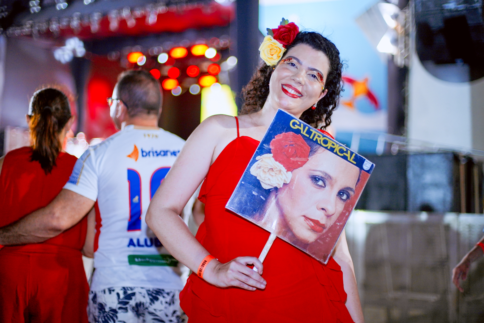 Camila Lopes fantasiada de Gal Costa e segurando uma capa de disco da cantora